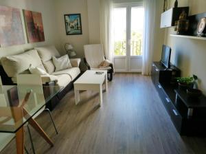 ein Wohnzimmer mit einem Sofa und einem Tisch in der Unterkunft Apartamento Plaza Compañia Jerez in Jerez de la Frontera