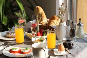 una mesa con alimentos para el desayuno y vasos de zumo de naranja en Villa Aruba & Private SPA Suites en Keszthely