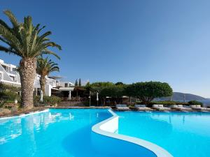 a large blue swimming pool with a palm tree at St. Nicolas Bay Resort Hotel & Villas in Agios Nikolaos