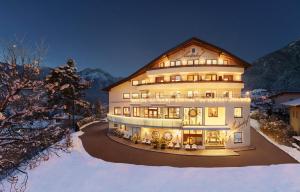 un gran edificio en la nieve por la noche en Hotel Arzlerhof, en Arzl im Pitztal