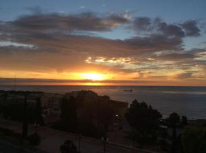 een zonsondergang over de oceaan met een boot in het water bij Lovely Apartments at Roman Circus in Tarragona