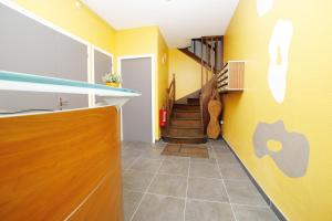a hallway with yellow walls and an apple sign on the wall at Appart-alma in Saint-Laurent-sur-Sèvre