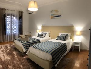 two beds in a hotel room with two lamps at Casa da Retorta in Alcains