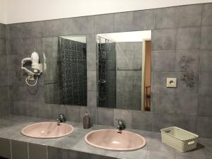 two sinks in a bathroom with two mirrors at Casa da Retorta in Alcains +42 photos