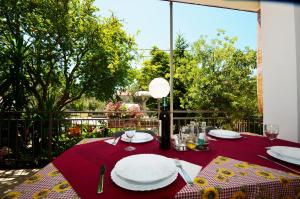 une table avec des assiettes et des verres sur un tissu de table rouge dans l'établissement Guest House Tinka, à Starigrad-Paklenica