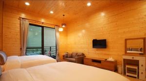 a bedroom with two beds and a television and a chair at Sunlight Forest in Dahu