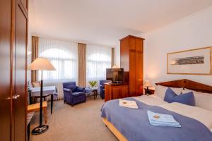 a hotel room with a bed and a desk at Aparthotel Seeschlösschen in Zinnowitz