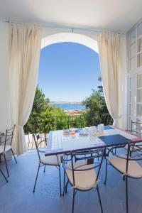 een eetkamer met een tafel en stoelen op een balkon bij Grand Hotel Palau in Palau