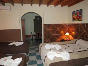 Habitación de hotel con 2 camas y toallas. en Hotel Pachá en Salta