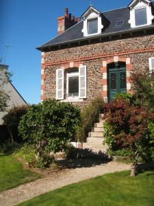 una casa de ladrillo con una puerta verde y escaleras en Maison de charme, en Binic
