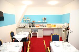 ein Esszimmer mit 2 Tischen und eine Küche in der Unterkunft Twinhof in Hamburg