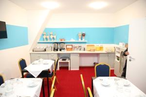 a dining room with two tables and a kitchen at Twinhof in Hamburg