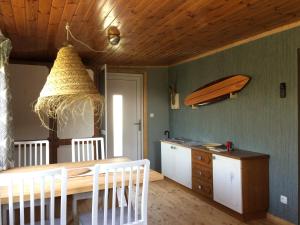 una cucina con tavolo e tavola da surf sul muro di Pfahlbau in Weiden am See a Weiden am See