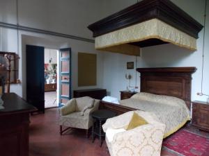 a bedroom with a large bed and a chair at Bed and Breakfast di Charme La Bonarella in Russi