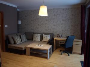 uma sala de estar com um sofá e uma mesa em Apartament przy parku em Breslávia
