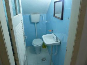 a blue bathroom with a toilet and a sink at Casa de praia in São Pedro da Aldeia