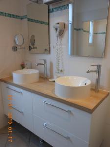 Baño con 2 lavabos y espejo en Hotel Villa Les Cygnes, en Niza