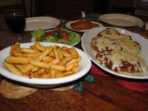 una mesa cubierta con platos de comida y patatas fritas en Hotel Pousada Arco Iris en Barra de Santo Antônio