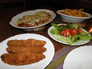 uma mesa coberta com pratos de comida e uma salada em Hotel Pousada Arco Iris em Barra de Santo Antônio