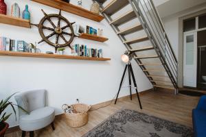 a living room with a wooden floor and a spiral staircase at GuestMar in Olhão
