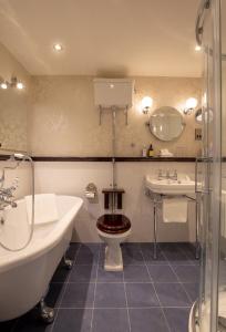 a bathroom with a tub and a toilet and a sink at Ghan House in Carlingford