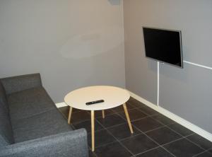 uma sala de estar com uma mesa e uma televisão em Elvis Stuga em Östersund