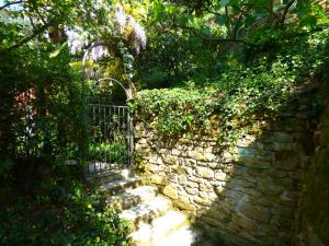 una pared de piedra con una puerta en un jardín en Apartments Olive Garden, en Piran