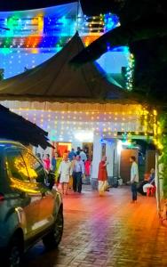 um grupo de pessoas andando em uma rua à noite em Grace Guest Home em Thrissur