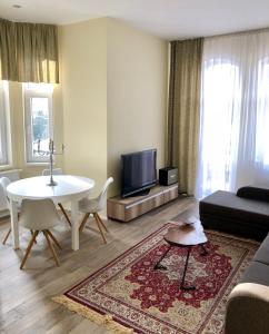 uma sala de estar com um sofá, uma mesa e uma televisão em Apartmán Marcello em Trencianske Teplice