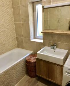 ein Badezimmer mit einem Waschbecken und einer Badewanne in der Unterkunft Apartmán Marcello in Trenčianske Teplice