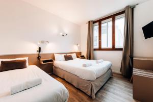 1 dormitorio con 2 camas y ventana en Hôtel Alizé, en Toulouse