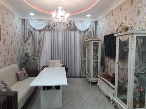 a living room with a couch and a tv and a chandelier at 2 Room Deluxe Apartment in Bakuriani in Bakuriani