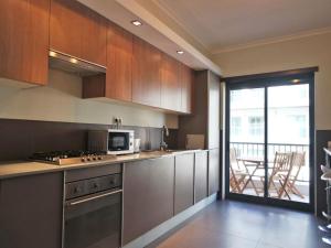 拉古什的住宿－B03 - Luxury 2 Bed Lagos Marina，一间带不锈钢用具的厨房和一个阳台