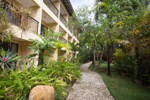 uma passarela num jardim ao lado de um edifício em Catussaba Business Hotel em Salvador