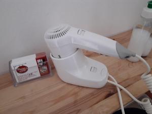 a white hair dryer sitting on top of a wooden floor at Marina's Rooms in Larnaca
