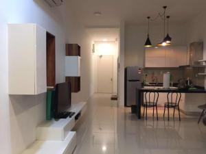 Una cocina con una mesa con sillas y un refrigerador. en The Loft Imago Studio Suites, Kota Kinabalu, en Kota Kinabalu