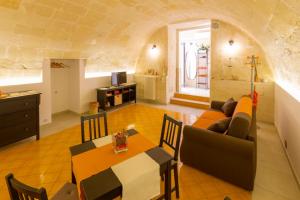uma sala de estar com um sofá e uma mesa em Alma Camere Affittacamere em Matera