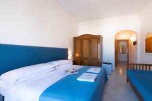 a bedroom with a large bed with a blue headboard at Hotel Europa in Ischia