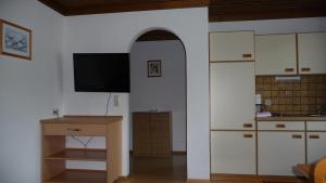 a kitchen with an archway and a television in a room at Haus Rieder Georg in Maria Alm am Steinernen Meer