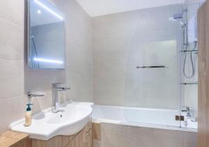 Un baño blanco con lavabo y ducha en Riverbank View Three Bedroom Apartment with Free Parking, en York