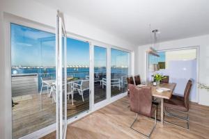 a dining room with a table and a view of the ocean at Maine in Olpenitz