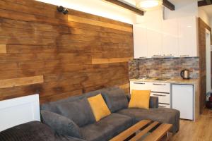 a living room with a couch and a wooden wall at Cozy Apartment Near Gondola loft1 in Gudauri