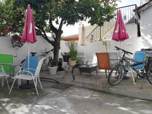 a patio with chairs and tables and umbrellas at Marina's Rooms in Larnaca