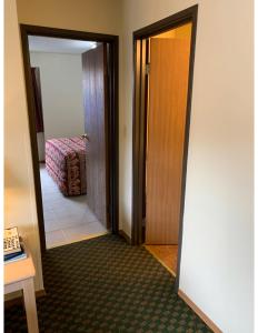 
a room with a bed, mirror and a door at Kings Inn Cody in Cody
