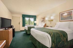a hotel room with two beds and a flat screen tv at Travelodge by Wyndham Morrill in Morrill