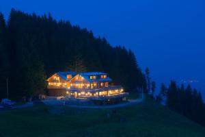 ein großes Haus auf einem Hügel bei Nacht in der Unterkunft BöckLodges in Nesselwang