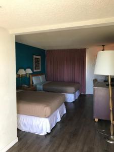 duas camas num quarto de hotel com paredes azuis em Delos Reyes Palm Springs em Palm Springs