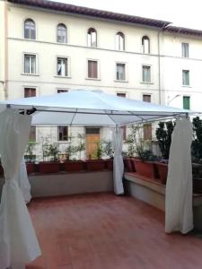 un ombrellone bianco su un balcone con un edificio di B&B BARBERA a Firenze