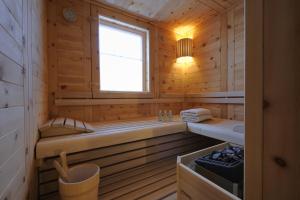 een houten hut met een bad en een raam bij BöckLodges in Nesselwang