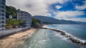 a body of water with a beach and buildings at Costa Sur All Inclusive Resort in Puerto Vallarta